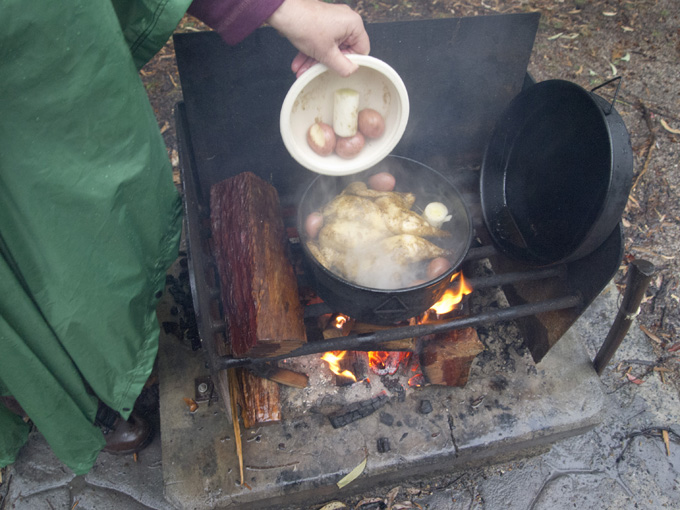 Adding the spuds and leeks to the chicken in the Bedourie Oven