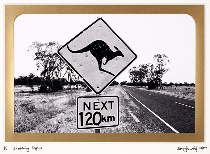 K Kangaroo – An endemic Australian species often so prolific in number that road signs are erected to warn motorists of their presence. The signs are also useful as a test of shooters skill if a shortage of the real thing exists. Judging by this example the Roos have a fair chance. West of Nyngan, New South Wales.